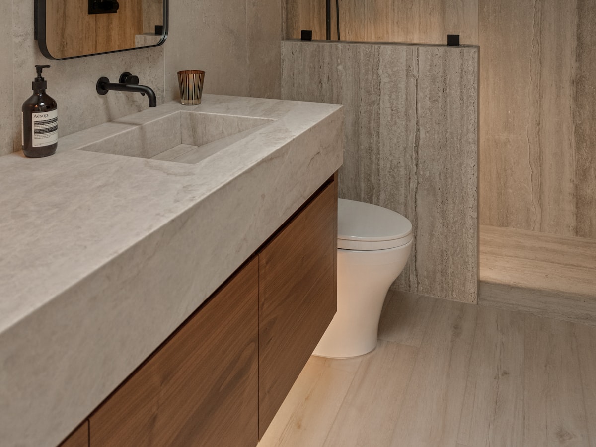 Finished bathroom with stone tiles and a timber vanity