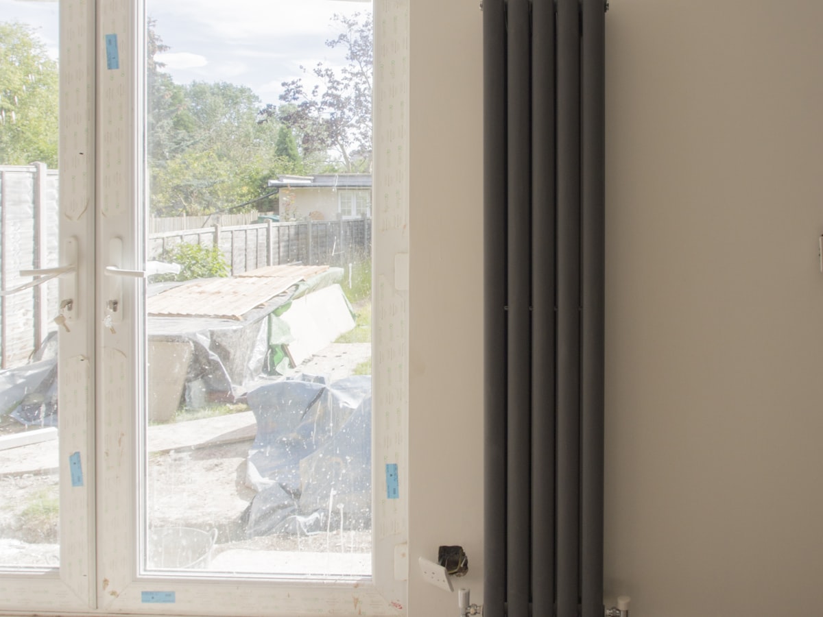 Two grey-green column radiators newly plumbed and connected